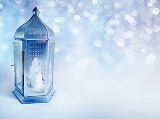 Ornamental Arabic lantern with burning candle glowing at night. Greeting card, invitation for...