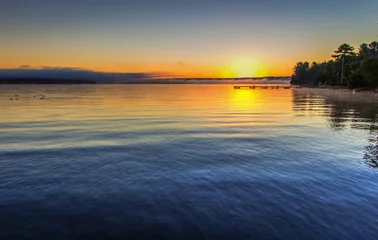 Foto auf Acrylglas Foggy Summer Lake Sunrise Panorama. Sunrise over Lake Superior on a foggy summer morning with a small wooden dock at the horizon. © ehrlif
