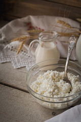 Fresh dairy products. Milk, cottage cheese, sour cream and wheat on rustic wooden background.