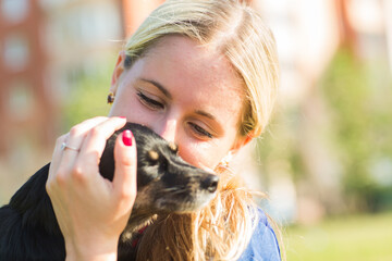 Concept of pets and happy owner - woman is holding a dog outdoors.