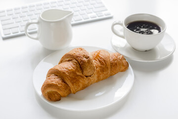 croissant and cup of coffee on office desk for business breakfast white background
