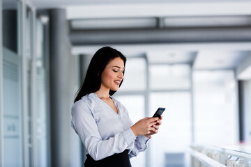 Fototapeta premium Woman at business building calling someone with phone