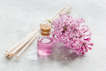 Fototapeta na wymiar spa cosmetic set with lilac flowers stone desk background