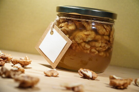 Jar with nuts in honey and white label, close-up