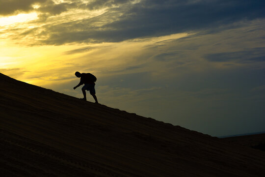 Silhouette man climb the mountain in morning with light sky background
