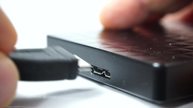 Details of male hand pushing incorrect and correct usb cable plug into usb slot on hard external disk 4K ProRes HQ codec