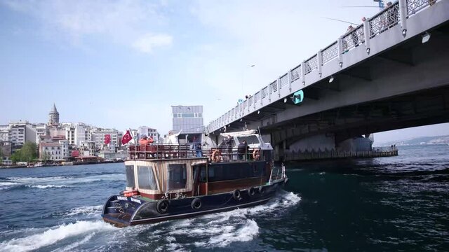 View of Bosphorus, boats and ferry passing under bridge