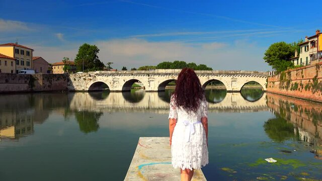 woman raising arms on pier in Rimini