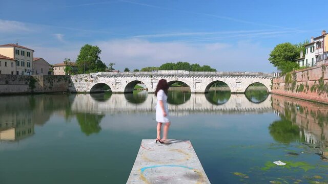timelapse of woman on dock in harbor channel in Rimini, Italy
