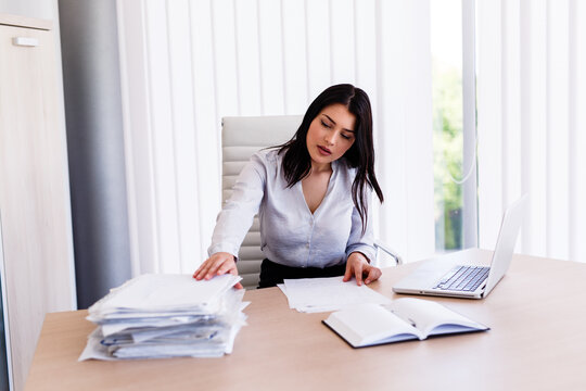 Businesswoman sitting in office and working with some documents