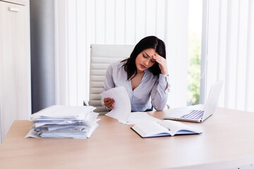 Businesswoman having headache in her office after doing very hard work