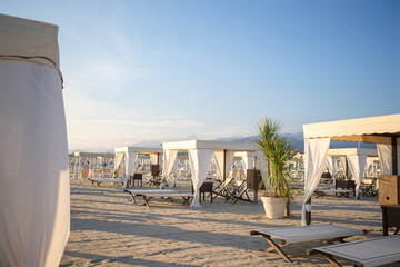 Wooden sunbeds in the evening soft light. Sunbeds in famous italian sand beach at Forte dei Marmi