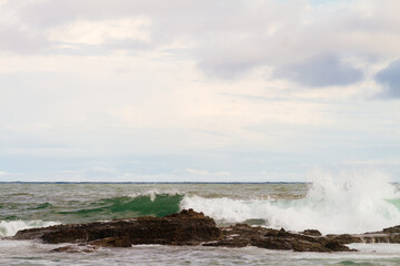 Fototapeta na wymiar Sea waves breaking against the rocks