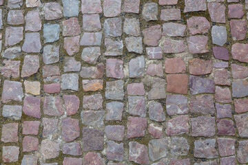 Stone granite cobblestoned pavement background or texture. Abstract background of old cobblestone pavement close-up in Prague