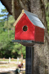 A wooden birdhouse painted red