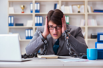 Businessman tied with chains to his work