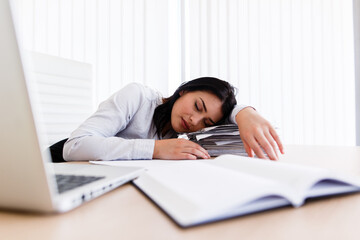 Tired woman sleeping on her work desk during the working time