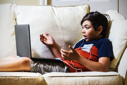 Adolescent boy with an expression of astonishment or shock using a laptop