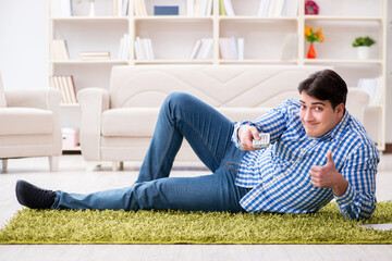 Obraz premium Young handsome man sitting on floor at home
