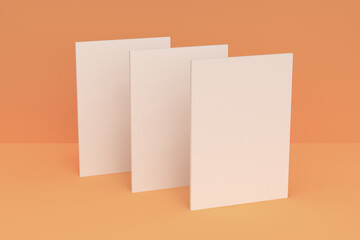 Three blank white closed brochure mock-up on orange background