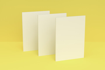 Three blank white closed brochure mock-up on yellow background