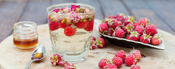 Obraz na płótnie Canvas Herbal tea with rose buds and fresh raspberry.