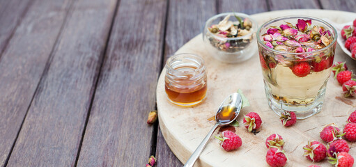 Herbal tea with rose buds and fresh raspberry.