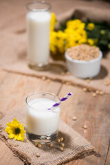 Soy milk or soya milk and soy beans in spoon on wooden table.