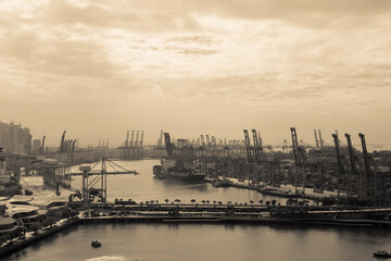 Obraz premium Container Cargo freight ship with working crane bridge in shipyard