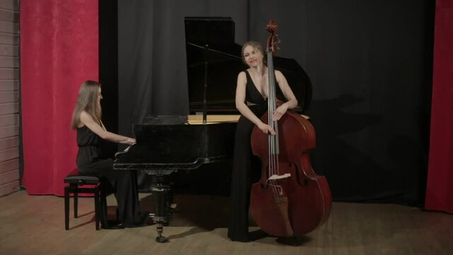 Two young women playing a musical instruments