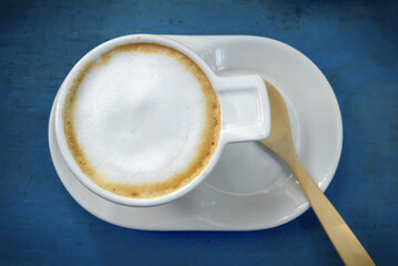 cup of cappuccino coffee on wooden table background