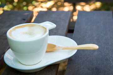 cup of cappuccino coffee on wooden table background