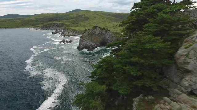 Fast forward close to grey cliff rocks Giant waves mountains. Far East marine reserve. Vladivostok national Park best Russia Primorsky nature. Stormy dark clouds. Epic cinematic aerial drone flight 4k