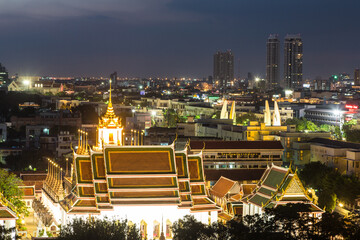 Fototapeta premium A night view of wat Thepthidaram from the Golden Mount in Bangkok old town. This city is Thailand capital city and dotted with Buddhist temples.