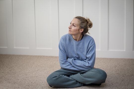 woman deep in thought struggle with depression while attempting to meditate or pray in her home.  Abstract photo of a woman contemplating life`s challenges