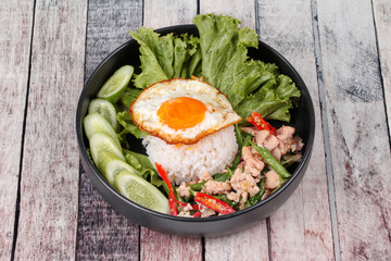 Jasmine rice topped stir - fried spicy basil with meat.