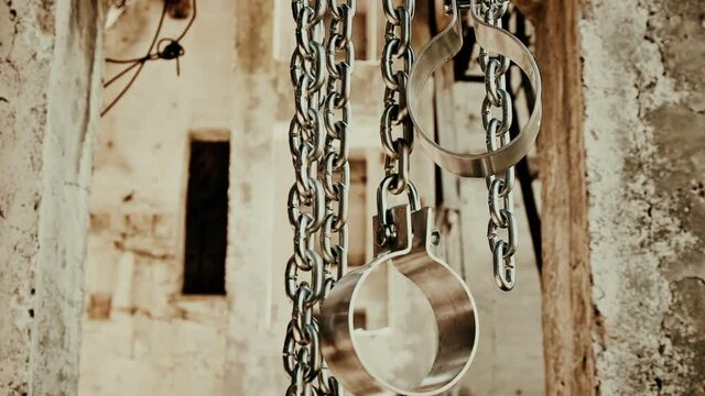 Chains with shackles hanging in an abandoned building