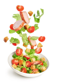 Flying salad ingredients isolated on white background. Caesar salad
