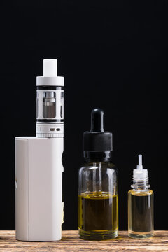 Electronic cigarette and aromas in bottles on a black background