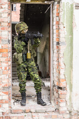 Portrait of armed woman with camouflage. Young female soldier observe with firearm. Child soldier...