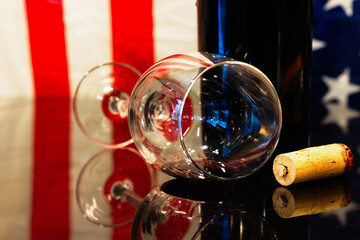 Wine glass,wine bottle on the table with American flag background.