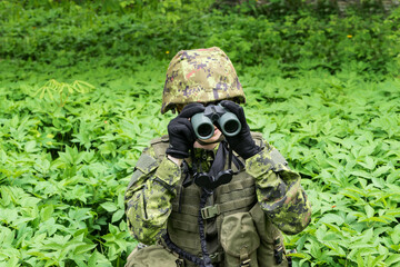 Portrait of armed woman with camouflage. Young female soldier observe with binoculars. Child...