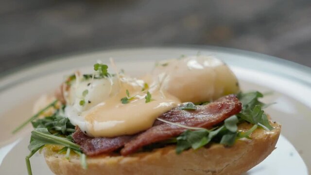 Eggs Benedict with bread and tomato on a plate with becon morning sandwich