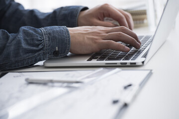 Men typing laptop computers in the office