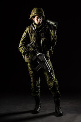 Portrait of armed woman with camouflage. Young female soldier observe with binoculars. Child soldier with gun in war, hause ruins background.  Military, army people concept