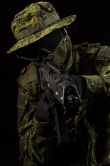 Portrait of armed woman with camouflage. Young female airsoft sniper observe with firearm. Soldier...