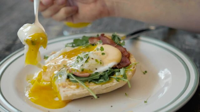 Eggs Benedict with bread and tomato on a plate with becon morning sandwich