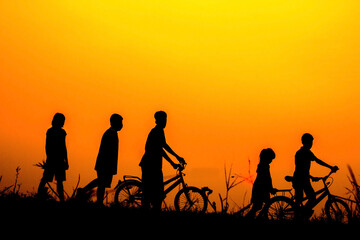 Fototapeta na wymiar Boys and girls standing a bike with sunset Silhouette.