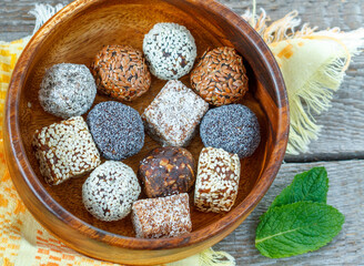 Healthy raw energy balls with cocoa, coconut, sesame, chia in a wooden bowl. Love for a healthy vegan food concept