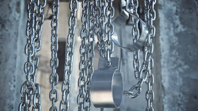 Chains with shackles hanging in an abandoned building